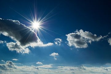 The sun and clouds on blue sky.