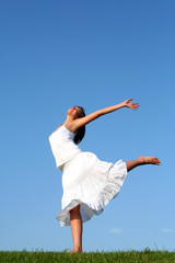 Wall Mural - Young woman dancing on grass