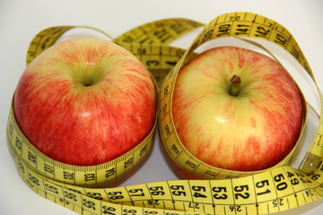 two red apples with a metric tape, symbol of health and diet