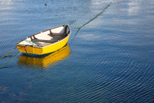 A Yellow Boat And Water Ripples.
