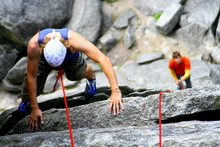 Climbing In Squamish British Columbia, Canada On Beautiful Granite Rock On An Easy Climb With Belayer In Foreground Blurred