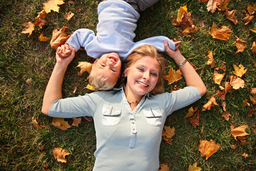 mother and son lied on autumn meadow