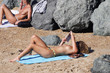 jolie fille en maillot de bain entrain de lire sur la plage