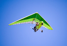 Airborne Motorized Ultralight Glider In A Cloudless Blue Sky