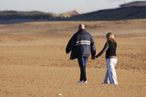 Fototapeta Kosmos - couple qui marche en se tenant la main sur la plage