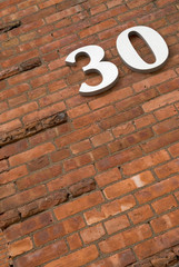 Wall Mural - Detail of an urban Brick building with the number 30 on it