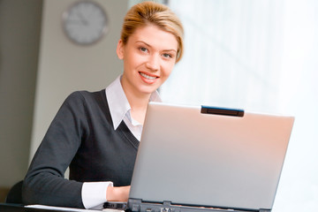 Poster - Portrait of pretty woman typing on the laptop in the office