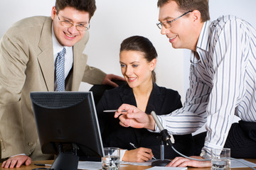 Canvas Print - Portrait of three business people looking at monitor of laptop