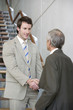 © carlosseller - Two businessmen shaking hands on a stairway