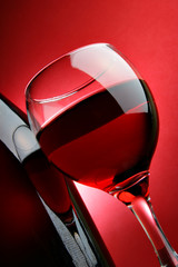 Still-life with glass of wine over red background