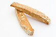 two frosted and nutty biscotti on a white background.