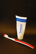 Photo of toothpaste tube and a toothbrush.