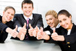 © pressmaster - Four business people sitting and holding their thumbs up