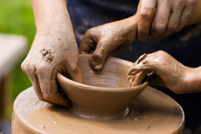 Potters Hands Guiding A Child To Help Him With The Ceramic Wheel