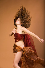 Beautiful young woman in silk throwing her hair back