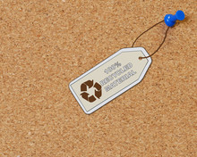 Recycled Material Tag Attached To Corkboard With Thumb Tack
