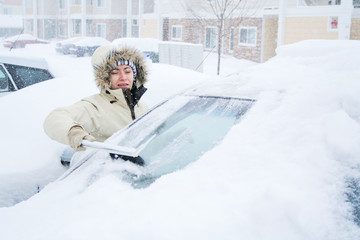 Wall Mural - Woman scraping snow off of windshield