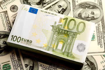 Poster - Close-up of heap of US dollars with a roll of euros on it