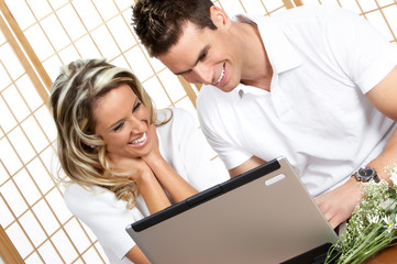 Canvas Print - Young love couple with laptop. Over white background  .