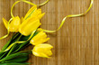 Yellow tulips on a bamboo mat. Copyspace for your text.