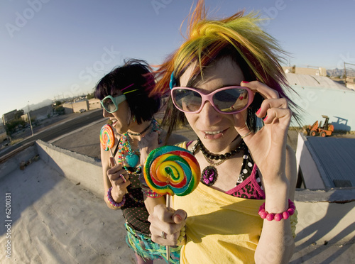 Fotografie, Obraz Fisheye shot of girls in brightly colored clothing on a roof