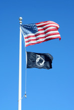 American And POW Flags Against A Blue Sky