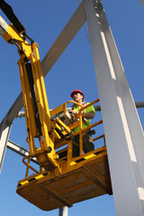 Steel worker operating a cherry picker