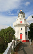 A Historic White Wooden Lighthouse On A Sunny Day