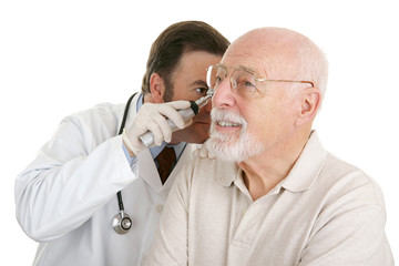 Senior man having his ears checked at the doctors office. 