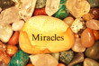 Stones and Crystals with a rock the says miracles on it