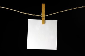 sheet of paper  hanging on a peg from a line