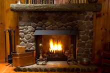 Close-up Of Stone Fireplace In Log Cabin With Blazing Fire