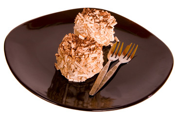 Two Chocolate Meringues on a black plate