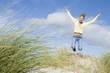 © Monkey Business - Young woman jumping amongst dunes