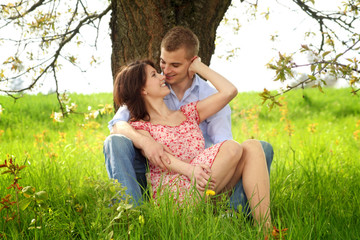 Wall Mural - young and happy couple is cuddle on a meadow