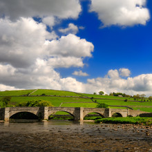 Bridge Over Peaceful Wharfe River In Yorkshire Dales National Pa