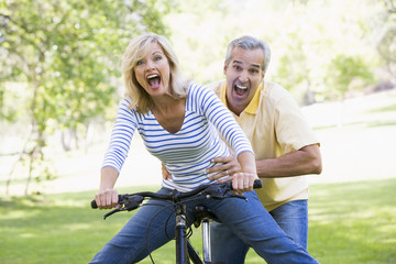 Wall Mural - Couple on bike outdoors smiling and acting scared