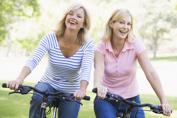 Two friends on bikes smiling