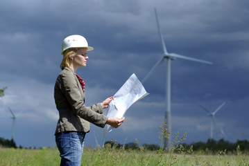 Wall Mural - Woman engineer or architect with white safety hat and wind turbi