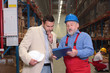 © endostock - boss and older worker talking over papers in warhouse