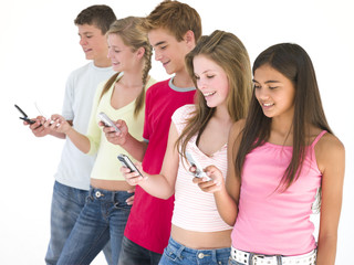 Row of five friends using cellular phones smiling