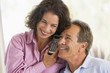 © Monkey Business - Couple indoors using telephone smiling