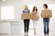 © Monkey Business - Three girl friends moving into new home smiling