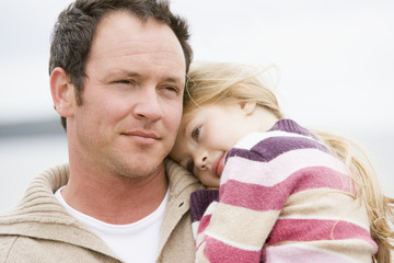 Father holding daughter at beach