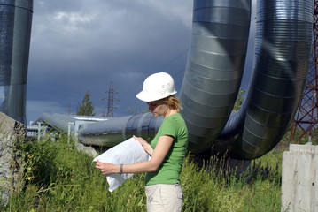 Woman engineer or architect with white safety hat, drawings and