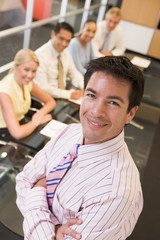 Wall Mural - Businessman with four businesspeople at boardroom table in backg