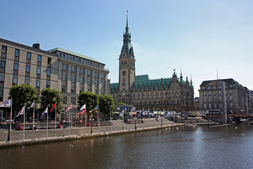 Das historische Hamburger Rathaus an einem sonnigen Tag. Vom Jungfernstieg aus geht der Blick über die Binnenalster.