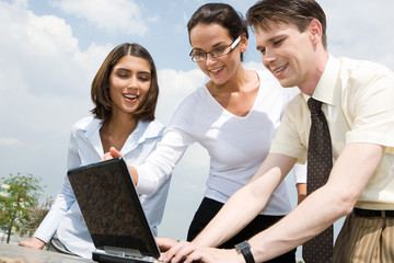 Sticker - Image of three business partners looking at laptop monitor