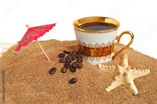 Naklejka dekoracyjna Gold cup with coffee, beans and starfish on a sea beach