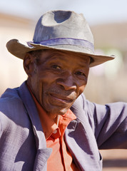 Portrait of elderly  african man with a broken had and old suit